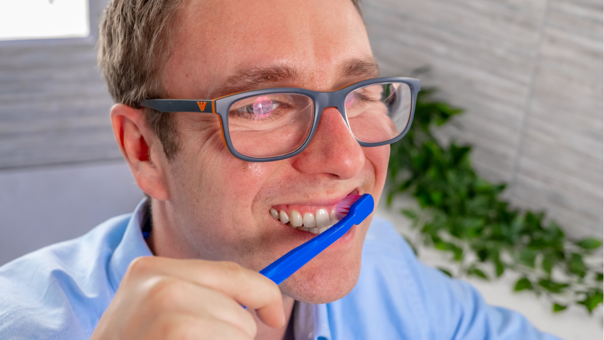 Jon using a manual toothbrush