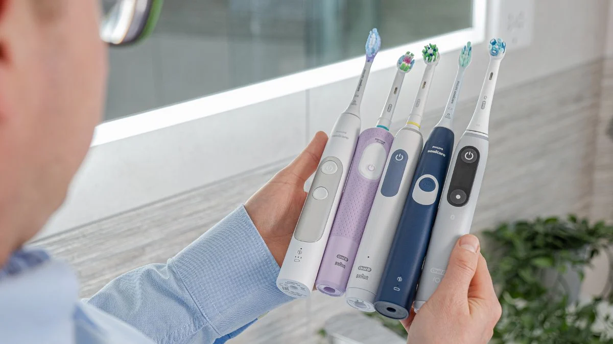Jon holding various Oral-B and Sonicare brush handles