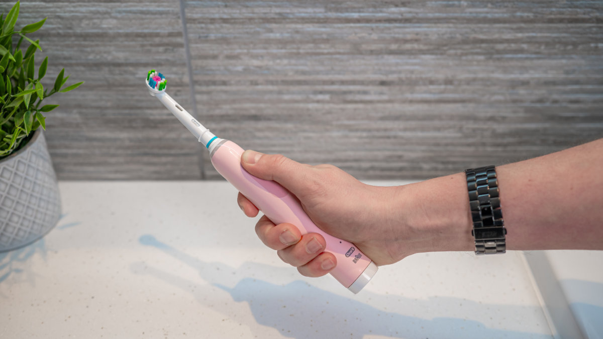 Thumb pressing power button on Oral-B Pro 3