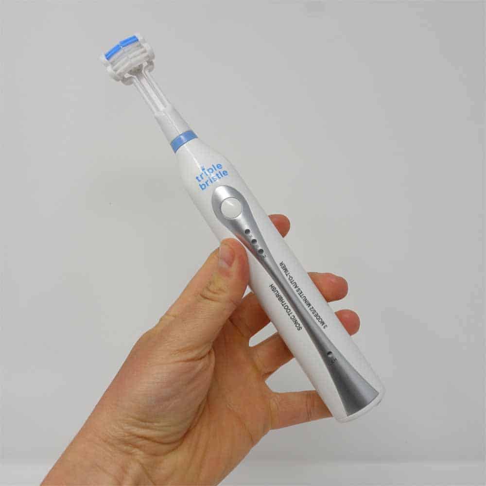 Sonic Original Triple Bristle toothbrush held in hand
