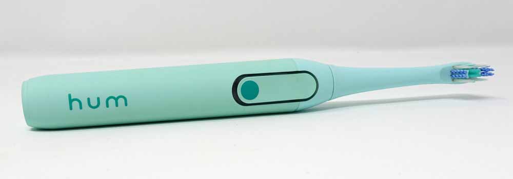 Teal colored Colgate hum laid on side