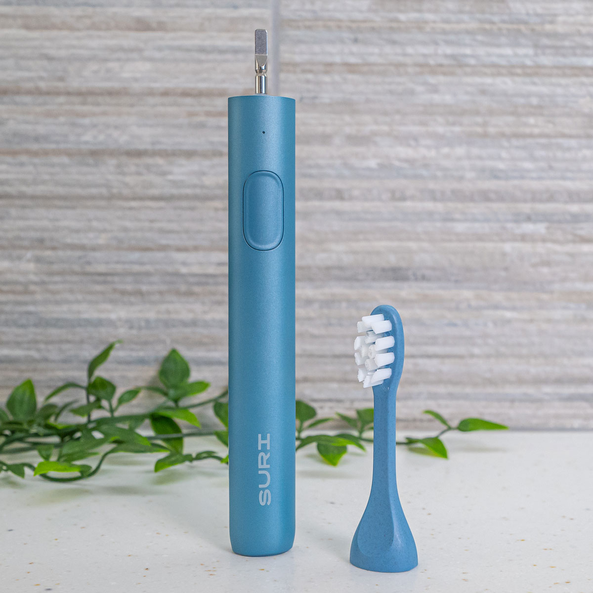 Plant based brush head for SURI toothbrush next to handle