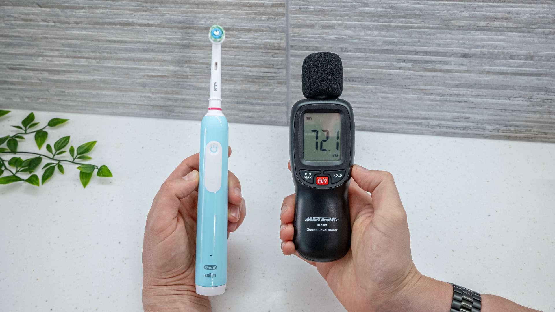 Electric toothbrush next to a decibel meter