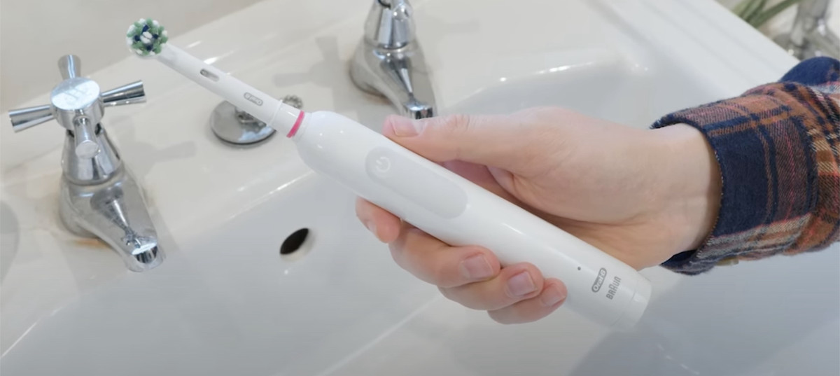 Oral-B Pro 1000 being held over the sink
