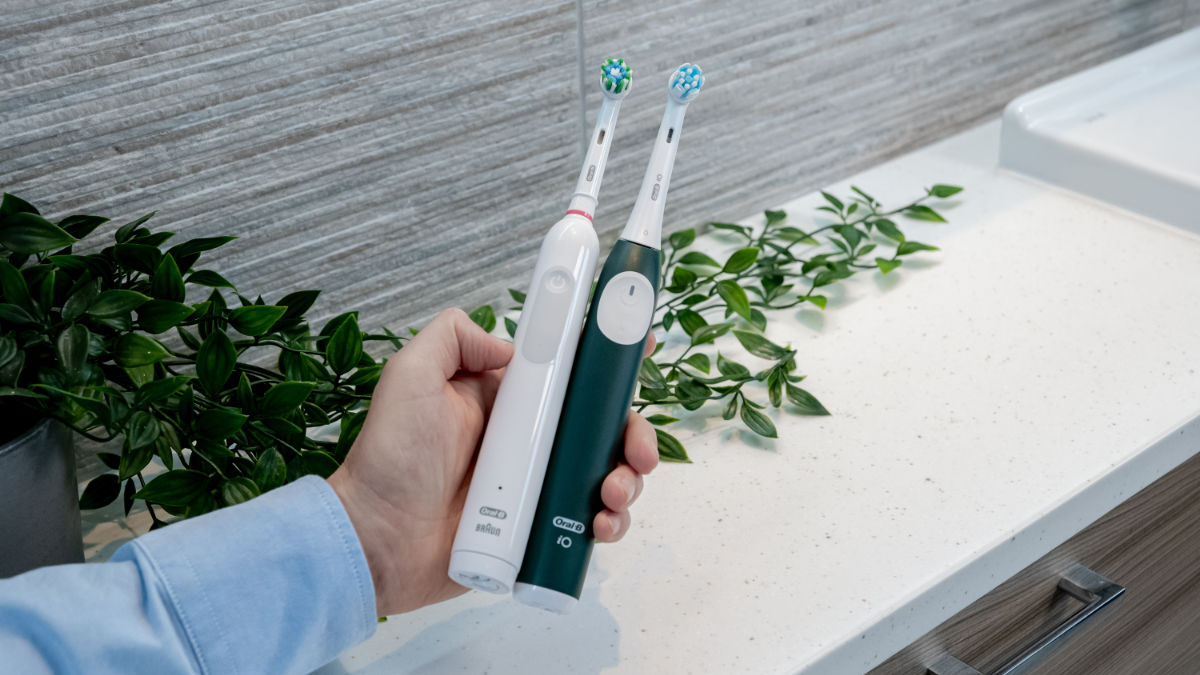 Oral-B iO2 and Pro 1000 being held next to each other in hand