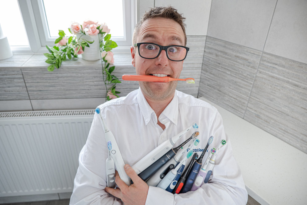 Jon Love holding an armful of electric toothbrushes